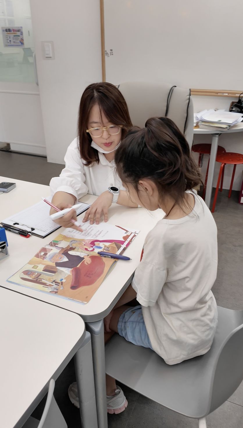 아이 옆에서 개별 지도하는 모습